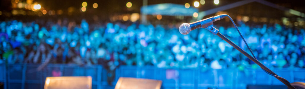 A view of the audience at the Aurora Performing Arts Festival focused on the microphone on stage